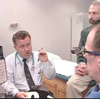 A doctor speaks with an individual with cerebral palsy and his personal care assistant.