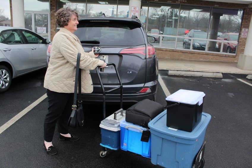 Trainer transporting supplies on a dolly/cart