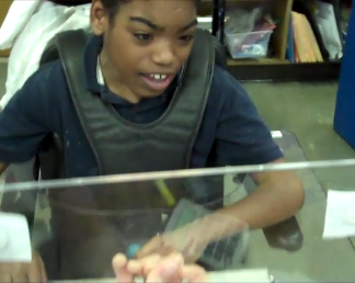 A student is using an acrylic board to work through a math problem.