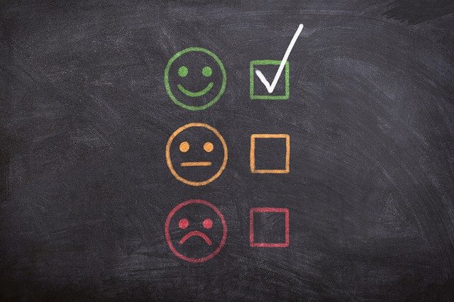 chalkboard with 2 faces and checkmark next to happy face