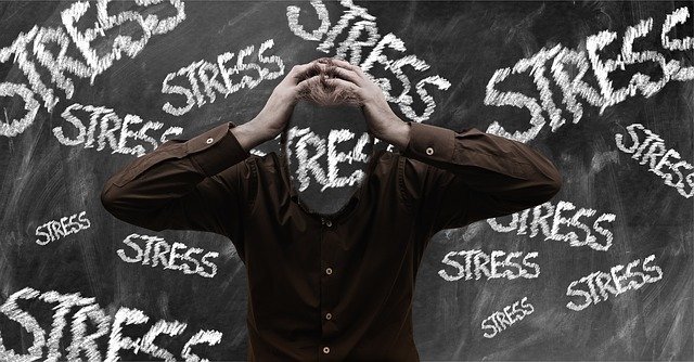 person holding head with the word stress written across the picture