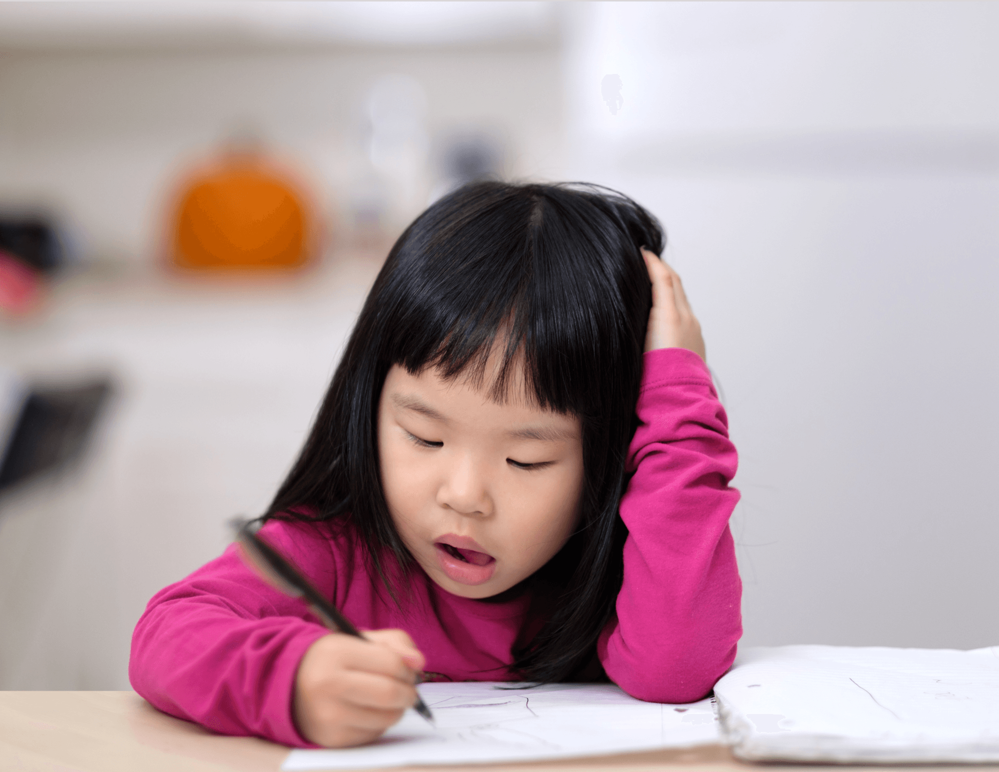 Young girl writing at a table.