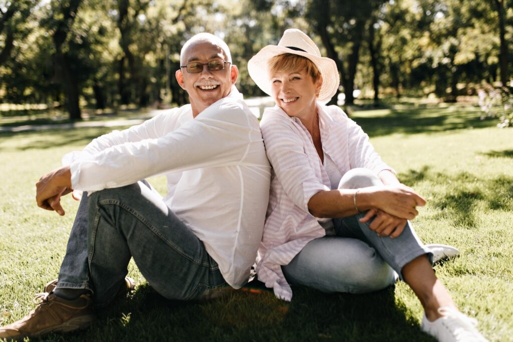 Man and woman sitting on the ground together.