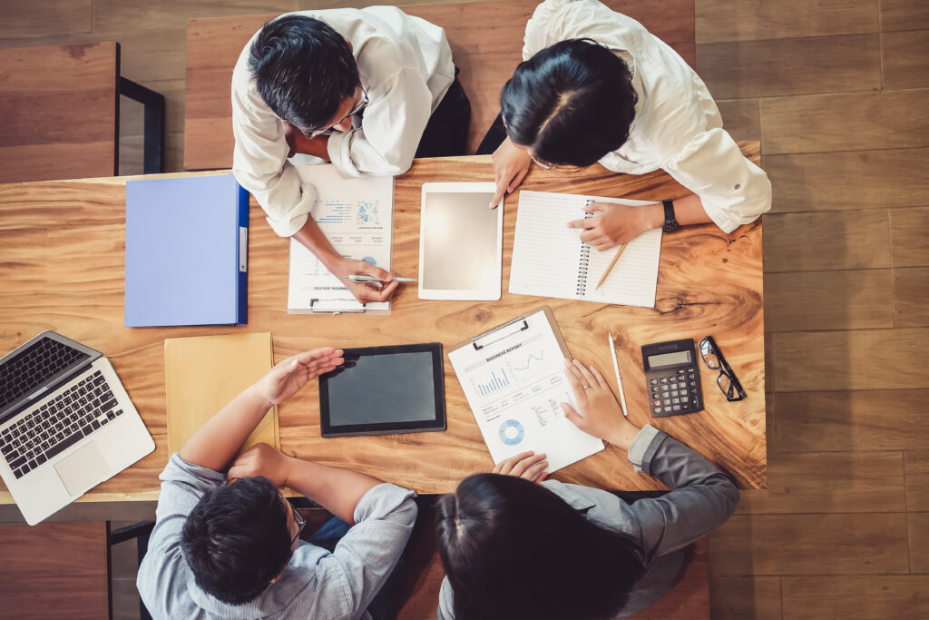 Asian business people meeting with new startup project pointing graph discussion and analysis data charts and graphs. Business finances and accounting concept