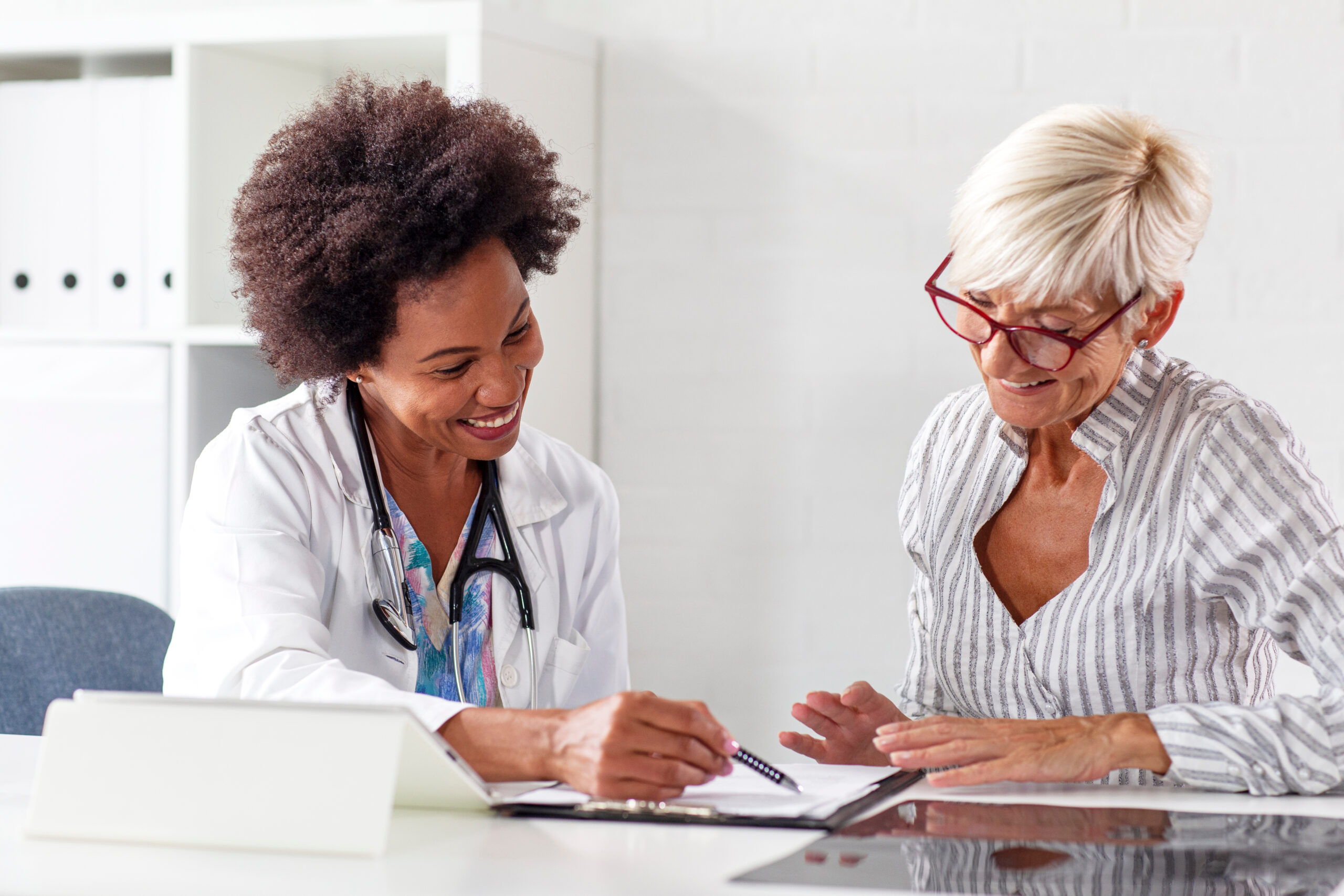 Woman sitting at a table with doctor