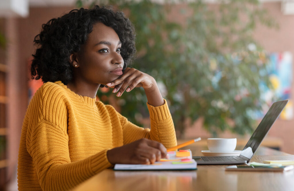 Woman sitting at a table with a thinking expression