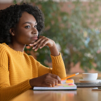 Woman sitting at a table with a thinking expression