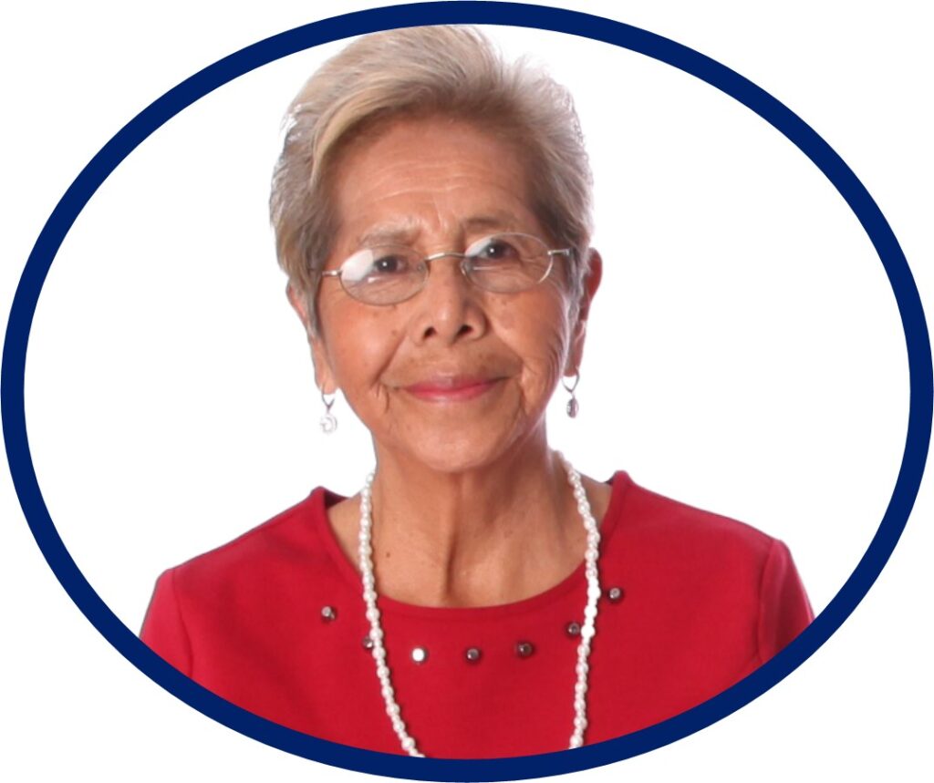 Older lady with short gray hair wearing glasses and a red top.
