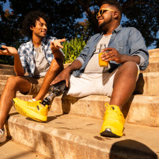 Two males talking while sitting on steps outside.