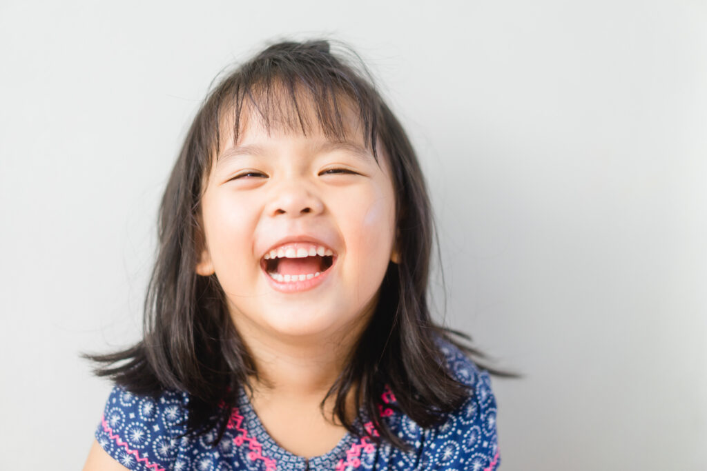 Young girl looking at camera and laughing.
