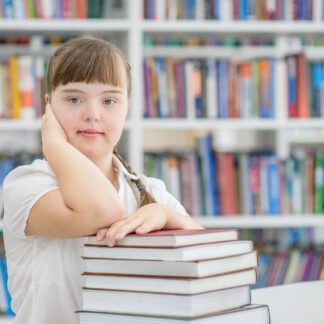 Portrait of a young girl with special needs at library.