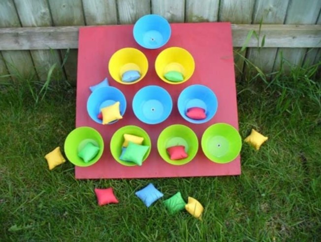 Bean bag toss game with cups and bags for throwing.