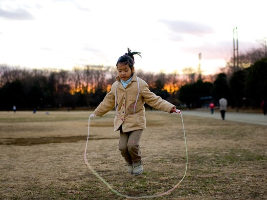 Young girl using a jump rope outside.